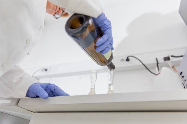 female researcher preparing white wine for distillation.